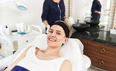 Beautiful woman with beautiful smile relaxing on massage table on the background of blurry...