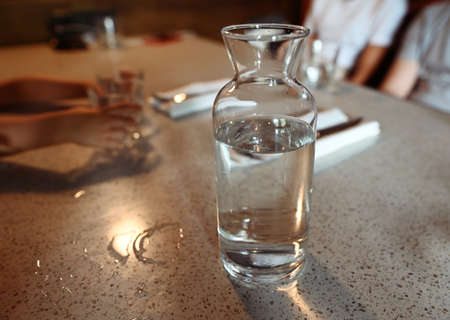 Transparent glass carafe or jug with water on a tableの写真素材