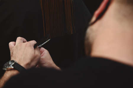 Close-up of haircutting. Hairdressing. Master of hairstyles cutting woman's hair in beauty salonの写真素材