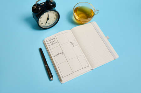Time management, deadline and schedule concept: alarm clock on schedule plan, organizer with plans,...