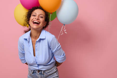Cheerful young Latin American woman with joyful and happy emotions laughing looking at camera,...