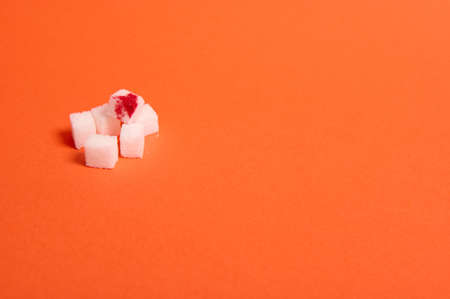 Pure refined white sugar cubes with blood drop isolated over colored orange background with copy space for medical advertising. World diabetes day awareness concept, 14 November.の写真素材