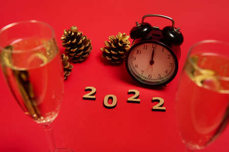Composition with wooden numerals, 2022 year, black alarm clock with midnight on the clock face,...