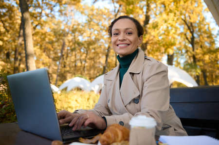 Attractive woman with beautiful smile, business person, freelancer works on laptop , enjoying...