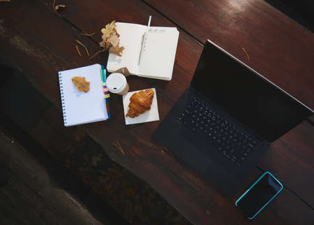 Flat lay composition of business and office items. Laptop, smartphone, open copybook, notepad and...