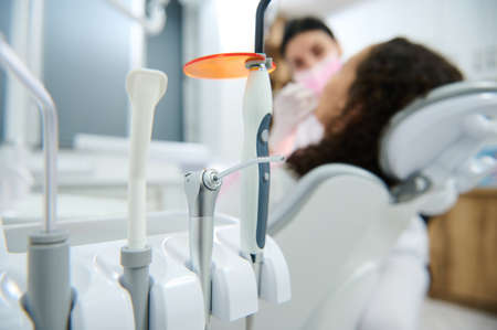 Focus on modern dental equipment used in dentistry on the background of blurred dentist using modern...