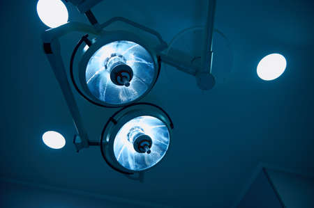Bottom view to blue filter light, medical surgical electric lamp in modern operating room in hospital. Medical concept, copy space. Lighting in surgeryの写真素材