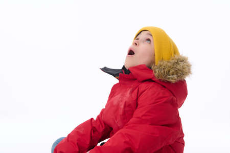 Close-up of handsome surprised amazed European elementary aged boy in bright yellow woolen hat and...