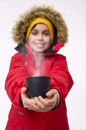 Charming cheerful school-age boy in bright warm clothes smiles toothy smile, looking at the camera,...