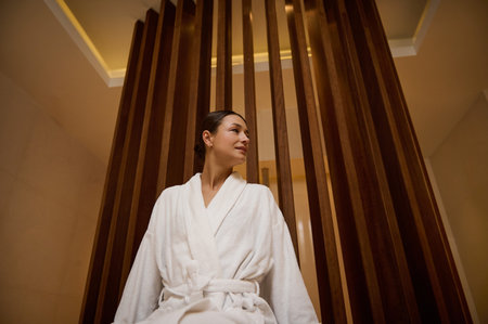 Portrait of a relaxed serene gorgeous elegant middle aged 30- 40 years old European woman in white terry robe enjoying vacation relaxing at spa resort. Recreation, body care and leisure conceptの写真素材