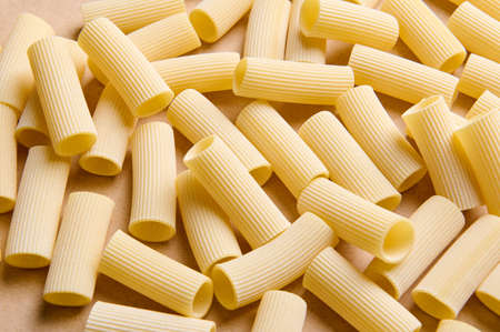 Pasta pattern. Top view of a heap of uncooked whole wheat tortiglioni italian pasta. Food backgroundの写真素材