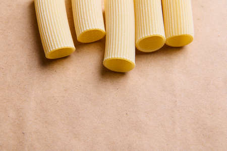 High angle view of one type of pasta on a craft paper surface with copy space. Raw tortiglioni and cannelloniの写真素材
