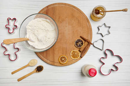 Flat lay. Top view of ingredients for preparing dough and gingerbread cookies, cutting molds, bottle...