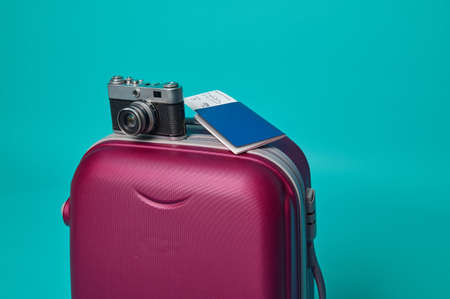 Close-up. Studio shot .Vintage camera and passport with ticket and boarding pass on a suitcase...