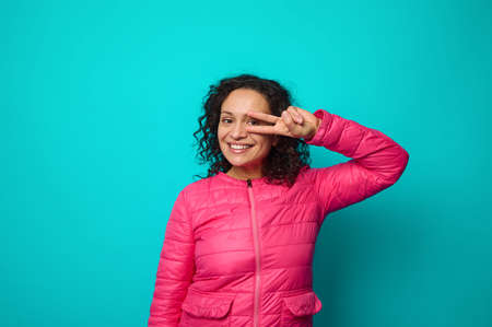 Emotional portrait of beautiful curly-haired woman smiling with cheerful toothy smile looking at...