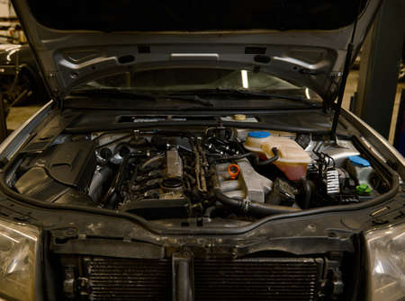 Close-up. Car engine details, motor of a car with open hood. Auto service, maintenance, warranty...