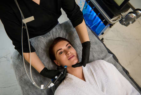 Beautiful Caucasian woman lying on a massage table and getting a hydro microdermabrasion facial...