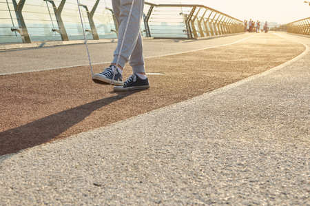 Sportsman during morning cardio workout with jumping rope on city bridge at dawn. Close-up of the legs of a male athlete exercising outdoors with a skipping rope. Motion, active and healthy lifestyleの写真素材