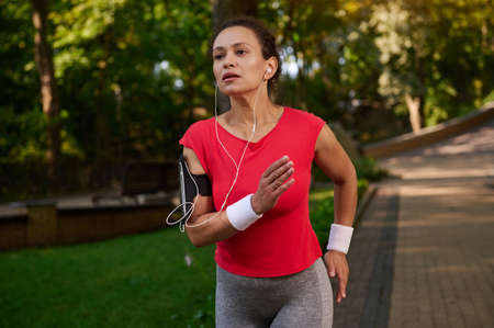 Stunning attractive exhausted strength muscular Hispanic sportswoman, athlete, runner with healthy...