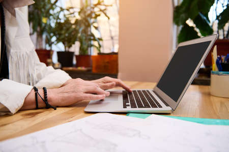 Detail of the hands of a fashion designer on the laptop keyboard