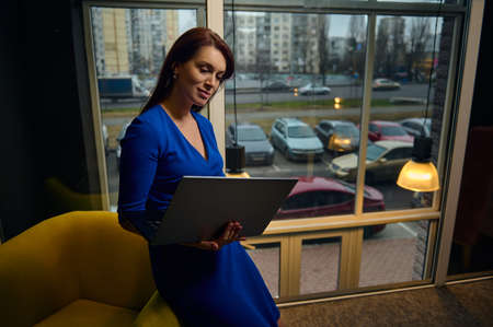 European charming woman- interior designer, businesswoman, sales manager sitting in a yellow nouveau...