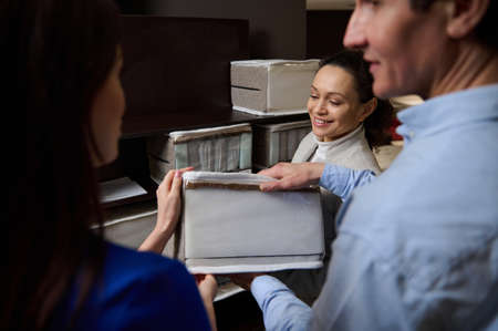 Focus on a pleasant sales manager showing customers buying bed linen a sample of an orthopedic mattress in a furniture store. Healthy sleepの写真素材