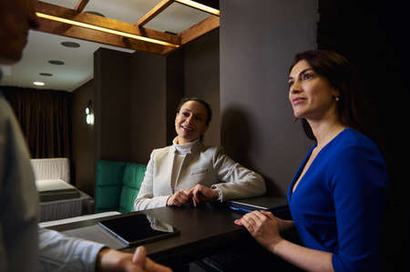 Middle-aged European married couple shopping for new furniture, talking with a retail consultant in home design studioの写真素材