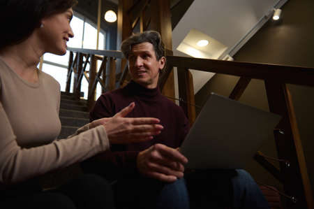 Friendly creative and inspired team of a handsome mature Caucasian man a charming woman working on...