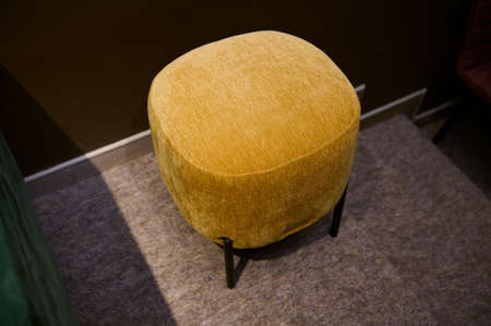 Stylish velour yellow footstool, ottoman in the furniture design studioの写真素材