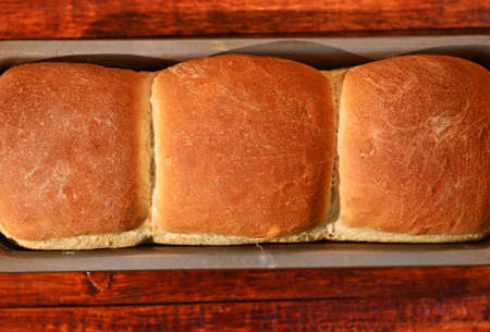 Flat lay. Food composition of a freshly baked hot whole grain bread,on a wooden background with copy ad spaceの写真素材