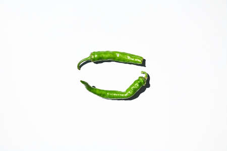 Flat lay composition of green chili peppers, isolated on white background. Copy space. Top view. Horizontal studio shotの写真素材