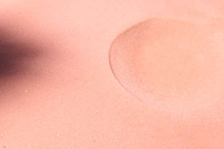 A formed crater on pure pink sand. Sandy background. Copy space for promotional and advertising textの写真素材