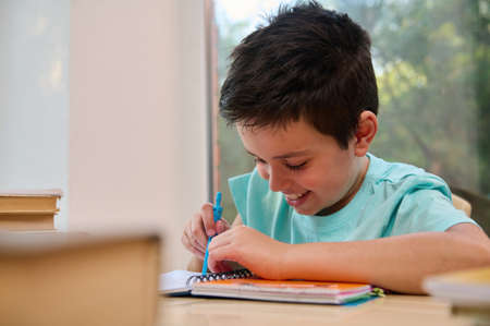 Close-up smart schoolboy using compass for drawing, draws circle while doing math and geometry...