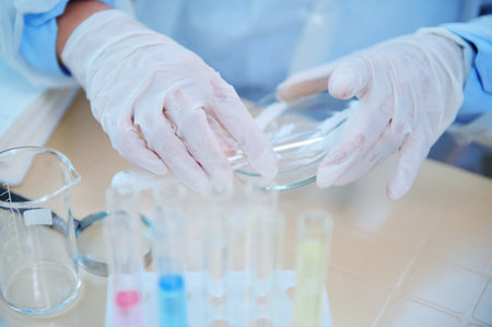 Selective focus on the hands in protective medical gloves of a lab assistant, laboratory technician,...