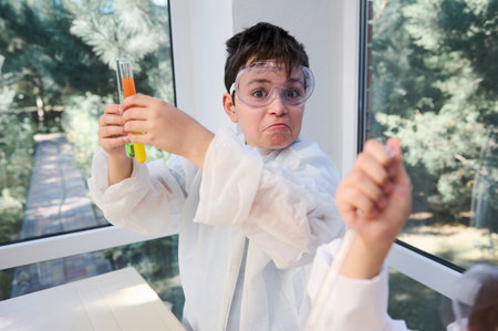Caucasian curious smart child, a schoolboy looking at the camera while making chemical experiments in chemistry laboratory. Chemistry education. Back to school on new semester of new academic yearの写真素材