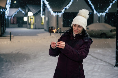 Pretty multi-ethnic woman lighting sparklers, Bengal lights while walking on a city street,...