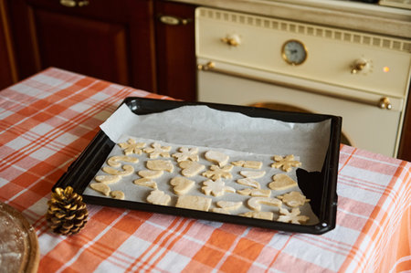 Homemade Christmas cookies, carved from gingerbread dough in the shape of heart, candle, candy cane,...