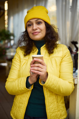 Confident portrait of a delighted attractive Middle-Eastern curly brunette woman, dressed in green...