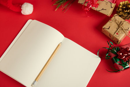 Top view of a wooden crayon on an open notepad or New Year agenda with blank paper sheets, copy...