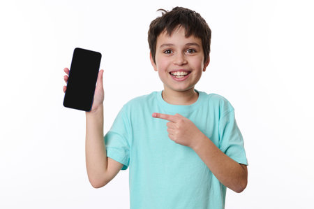 Wow awesome mobile app. Handsome Caucasian teenage boy points at smartphone with black blank screen...