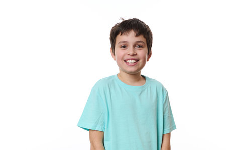 Emotional portrait of lovely Caucasian teen boy, smiling looking at camera, isolated on white background with free advertising space for your promotion. Smart schoolboy, teenager, pre-adolescent boyの写真素材
