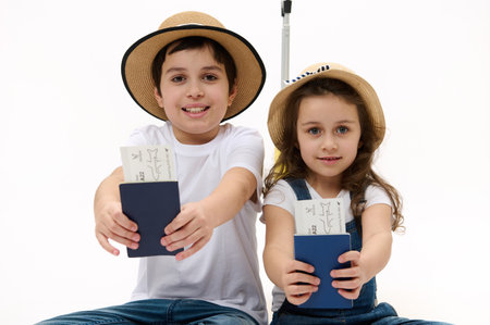 Happy journey! Family of travelers brother and sister wearing casual denim, white t-shirt and straw...