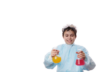 Isolated on white background: young chemist scientist, smart preteen schoolboy in laboratory coat, pouring chemical reagent in glass retort at chemistry class. Free ad space for your promotional textの写真素材