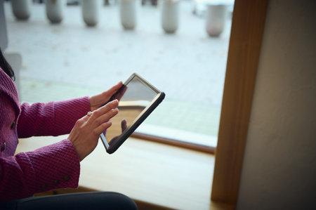 Close-up of hands of a businesswoman, entrepreneur working on digital tablet, sitting on the...