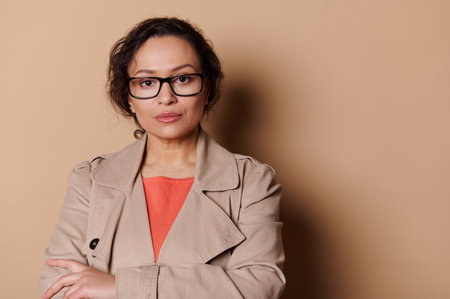 Confident portrait of a multi-ethnic middle-aged pretty woman, wearing stylish eyeglasses an?...