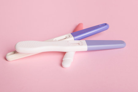 Rapid diagnosis of pregnancy at home. Pregnancy test kits with two bars on isolated pink pastel background. Copy ad space. Womens health, gynecology and medicine concept. Planning maternity conceptの写真素材