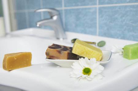 Craft organic soap bars on washbasin in the home bathroom. Purity. Hygiene. Home spa. Skin and body care concept.の写真素材