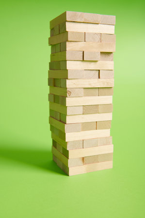 Wooden blogs stacked on isolated green background. Entertainment activities. Board game game of physical and mental skill, developing fine motor skills.の写真素材