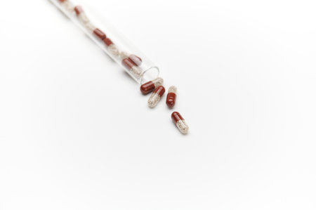 View from above of translucent gel capsules - medical pills, scattering from test tube, isolated on white background. Copy advertising space, Pharmaceutical business and industry. Therapyの写真素材