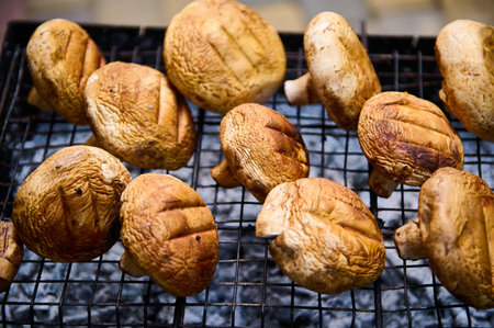 Mushrooms on grate grilled on barbecue, vegetarian vegan summer food. Preparing delicious food in the open air. Summer picnic and chill out concept. Close-up. Selective focusの写真素材